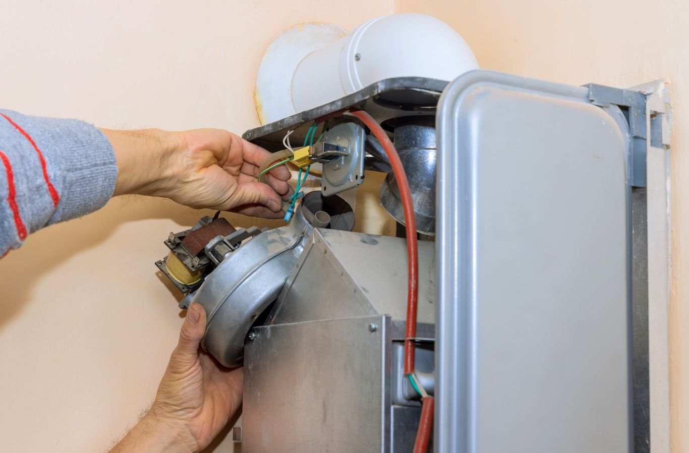 A Climate Systems expert working on a boiler in Adams Township, PA, highlighting the benefits of professional repair services.